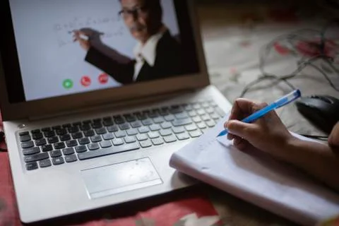 Hands on notebook while attending online classes at laptop in home isolation  Stock Photos