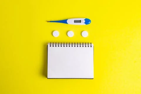 Hands with a notepad in rubber gloves with a thermometer on a yellow background Foto stock