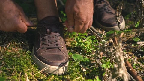 Hands of an old man tying the shoelaces on a shoe. Laces untied along the way Stock Footage 157072045
