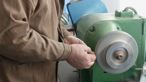 Hands old master grind detail on bench grinder, rough grinding machine, close Vidéo 105839941