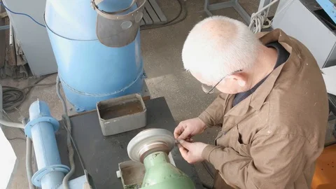 Hands old master grind detail on bench grinder, rough grinding machine, close Видео 105840002