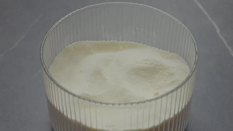 Hands open a container of powdered milk for easy access and use Stock Footage 327582298
