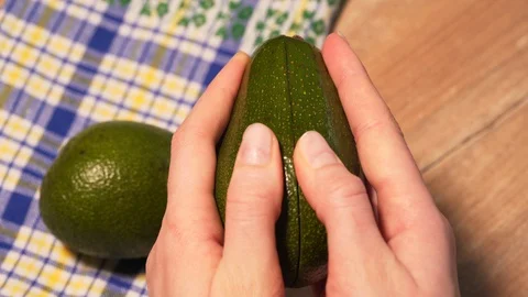 Hands open cut green avocado, first-person view Stock Footage 126179189