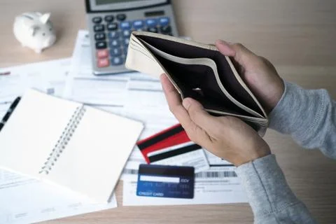Hands open the empty purse after calculating the cost from the credit card an Stock Photos