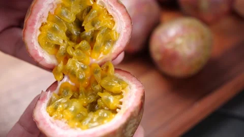 Hands open half passion fruit in slow motion. Passion Fruit for healthy eating Stock Footage 143373667
