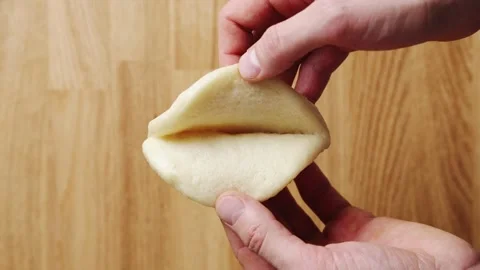 Hands open hot bao bun, revealing soft white centre. Stock Footage 341429706
