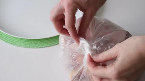 Hands Open Plastic Bag With Raw Chicken Legs And Pouring Out Them On A Plate Stock Footage 125094763