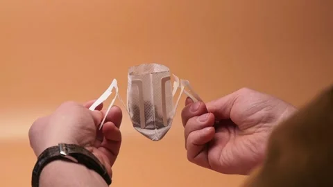 Hands open single serve filter coffee drip bag isolated Stock Footage 195524120