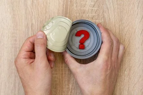 Hands open tin can in which is a question mark Stock Photos