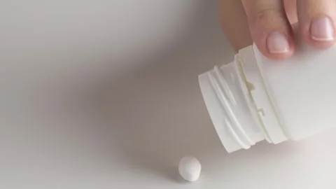 Hands open a vial of white pills. Woman taking pills out of the bottle. A woman Video stock 247353528