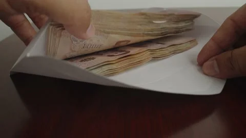 Hands open white envelope with thousands Thai baht banknotes. Stock Footage 237687391