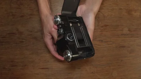 Hands Opening Back Of SLR Camera And Rotates Film Rewind Crank. overhead shot 動画素材 299899758