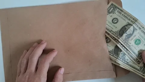 Hands opening a brown paper envelope. Person putting documents inside a mailing Stock Footage 340360118