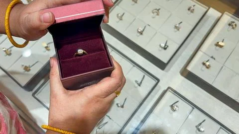 Hands opening burgundy ring box with diamond solitaire engagement ring 스톡 사진