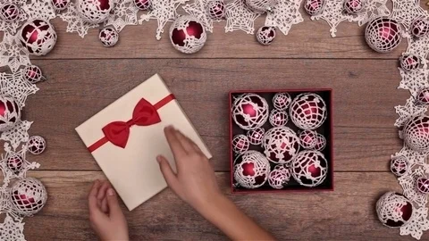 Hands opening christmas present inside seasonal decorations frame Видео 81022663