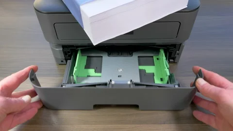 Hands opening an empty tray, with a ream of paper on top of the printer. Stock Footage