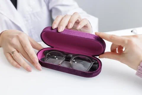 Hands opening eyeglasses case during optician consultation in optical clinic Stock Photos