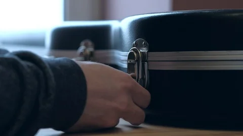 Hands opening guitar case lock. Beginning or performance concept. Stock Footage 102048838