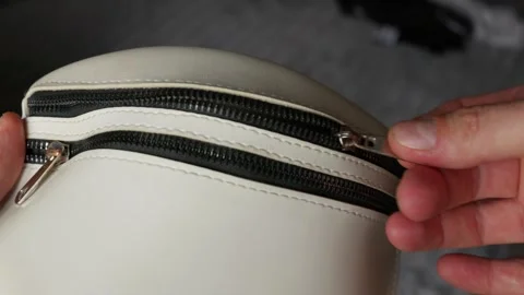 Hands Opening Metal Zipper on Small White Synthetic Leather Bag Video stock 338091896