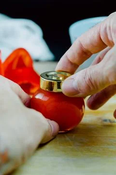 Hands opening one jar of red pepper jelly on table Stock Photos