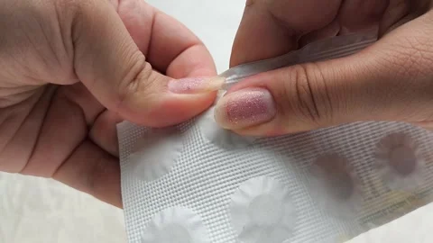 Hands opening a package of pills against. The concept of treatment. 動画素材 314880094