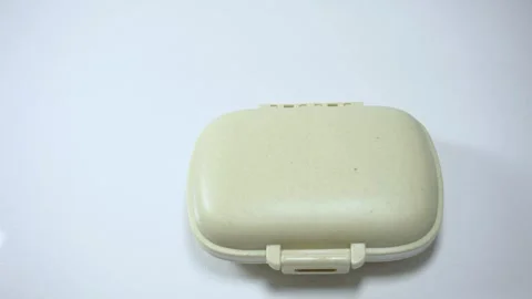 Hands opening pill organizer with tablets inside close up medication storage Vídeos de archivo 342838850