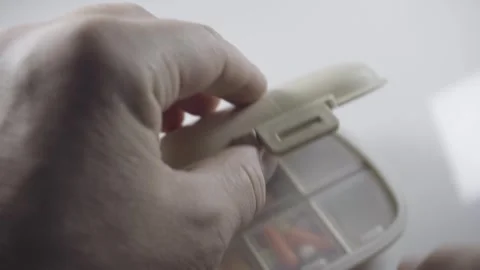 Hands opening pill organizer with tablets inside close up medication storage Stock-Footage 342838861
