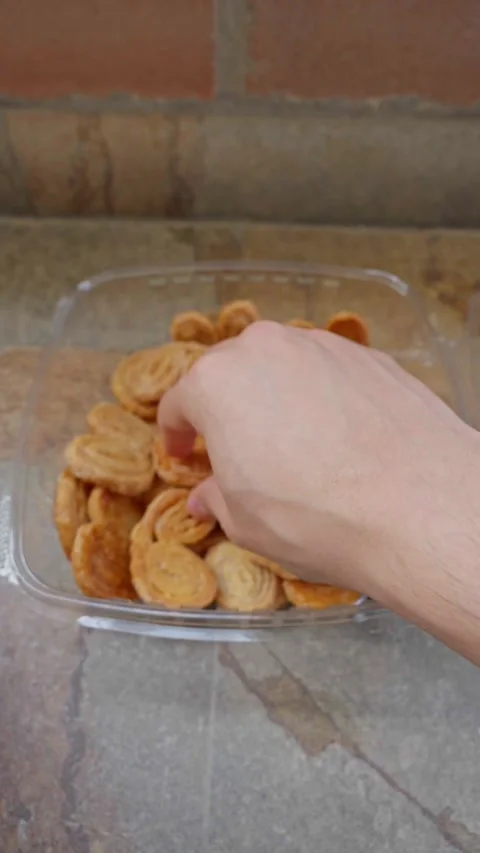 Hands Opening Plastic Box of Sweet Puff Pastry Hearts Covered in Sugar Stock Footage 284290453