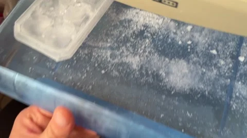 Hands opening plastic freezer ice tray with frozen cubes Stock Footage 336976549