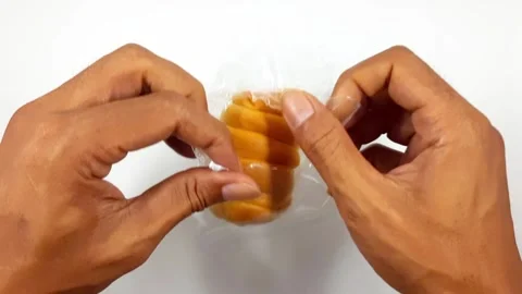 Hands opening plastic wrap to reveal sweet spiral bread pastry motion footage Video stock 330398431