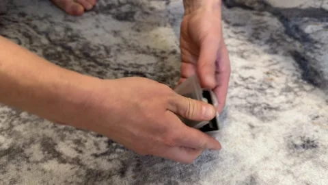 Hands opening a small plastic battery holder with cylindrical rechargeable Stock Footage 336976765