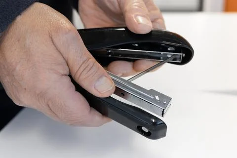 Hands opening stapler to load staples office maintenance task Stock Photos
