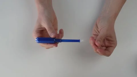 Hands opening a tampon shot overhead isolated on white Stock Footage 144681051