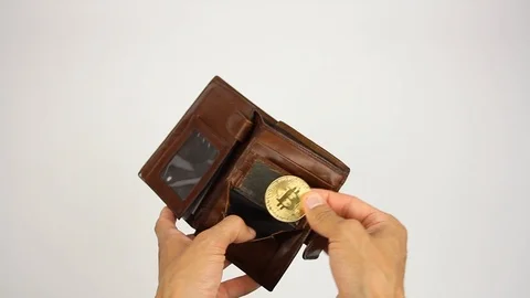 Hands opens brown leather wallet, takes golden coin bitcoin,white background Stockbeeldmateriaal 92373470