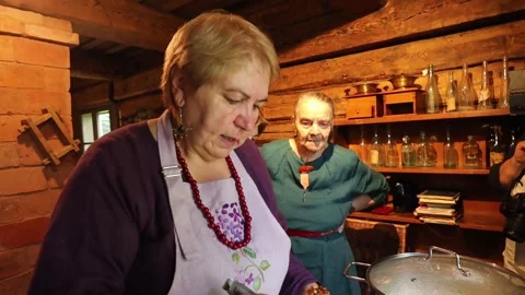 Hands operate a vintage cream separator, processing fresh milk in a rustic Stock Footage 320074283