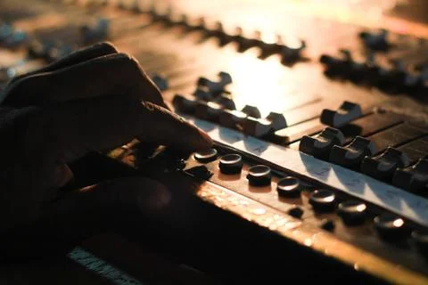 Hands operating buttons of light and sound board console at a concert theater Stock Photos
