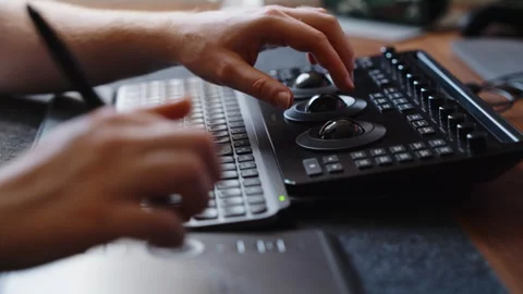 Hands Operating Color Grading Control Panel and Keyboard in Editing Studio Stock Footage 345692343