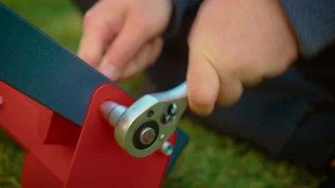 Hands operating ratchet wrench securing structural connection on painted metal Video stock 335144608