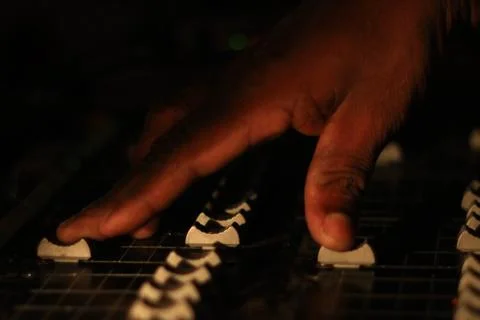 Hands operating slider of light and sound board console at a concert theater Stock Photos