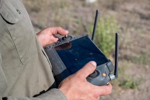 Hands of operator piloting agricultural drone. Stock Photos