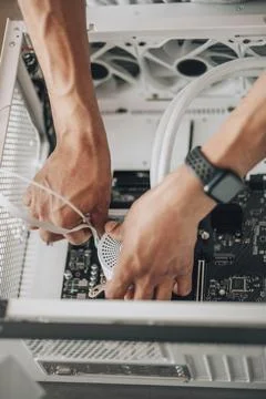 Hands orchestrating the assembly of a computer fan, symbolic of the intricate Stock Photos