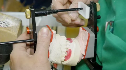 Hands of a orthodontics laboratory with a techician modeling a denture, teeth Stock Footage 59936063