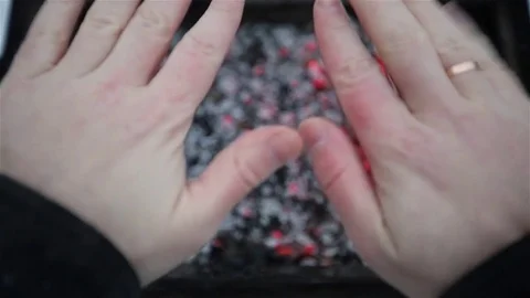 Hands over a brazier Stock Footage 70939089