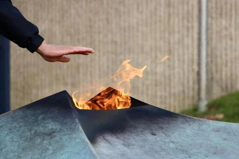 Hands over Eternal fire Stock Photos