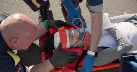 Hands, oxygen for first aid and a paramedic team with a patient or victim on the Stock Footage 252655972