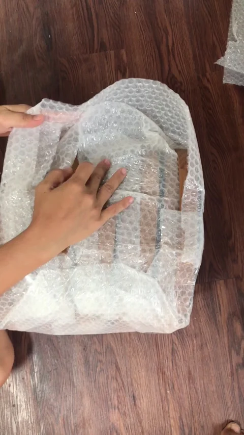 Hands Packaging Goods with Bubble Wrap Plastic and Adhesive Tape for Shipping 4K Stock Footage 337720683