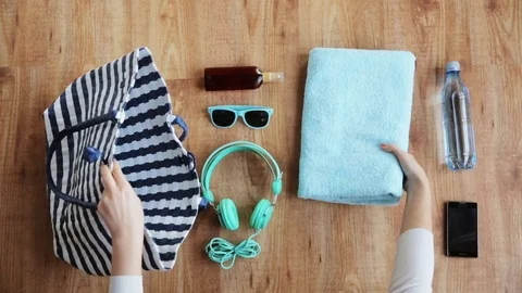 Hands packing beach accessories to bag 스톡 동영상 72402733