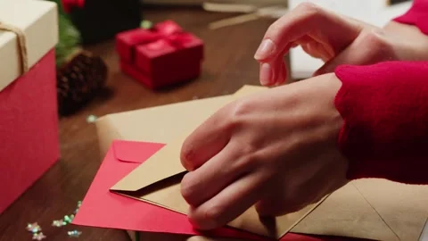 Hands packing Christmas new year or birthday gift box on a wooden desktop Stock Footage 255169423