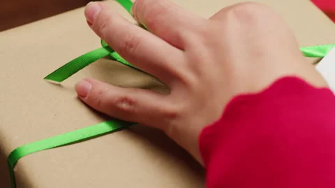 Hands packing Christmas new year or birthday gift box on a wooden desktop Stock Footage 255229125