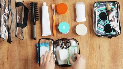 Hands packing cosmetic bag with stuff for travel Stock Footage 72402234